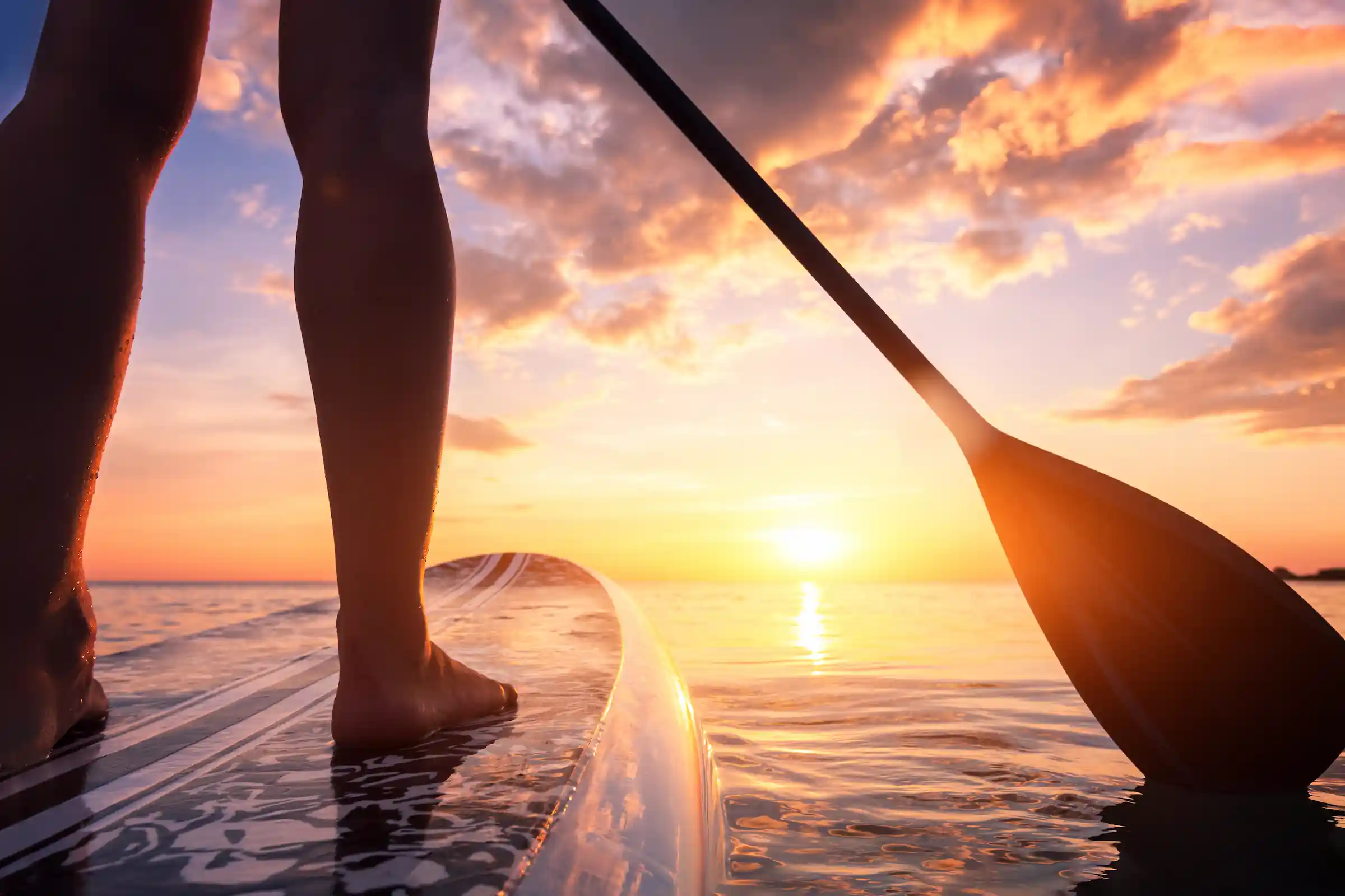 Stand up paddleboarding at sunset