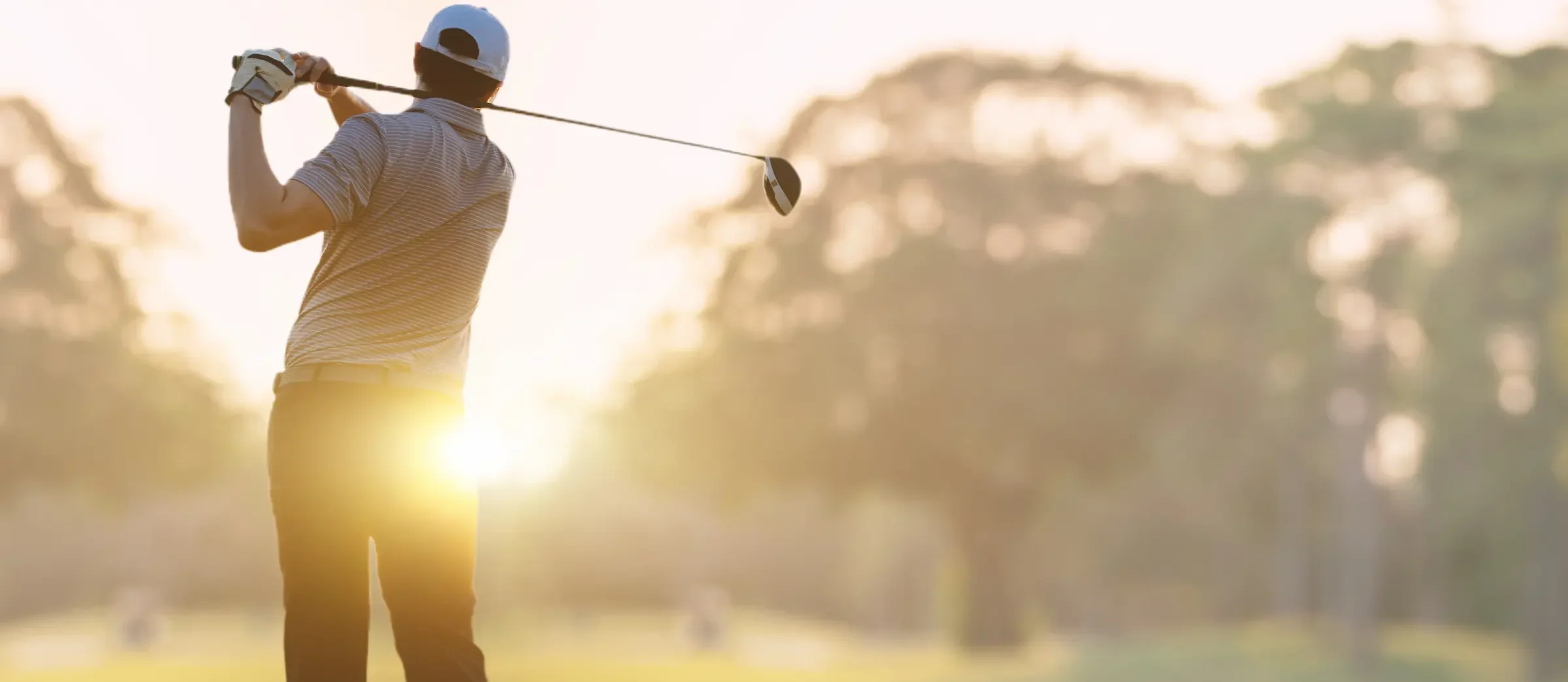 Man golfing at sunrise