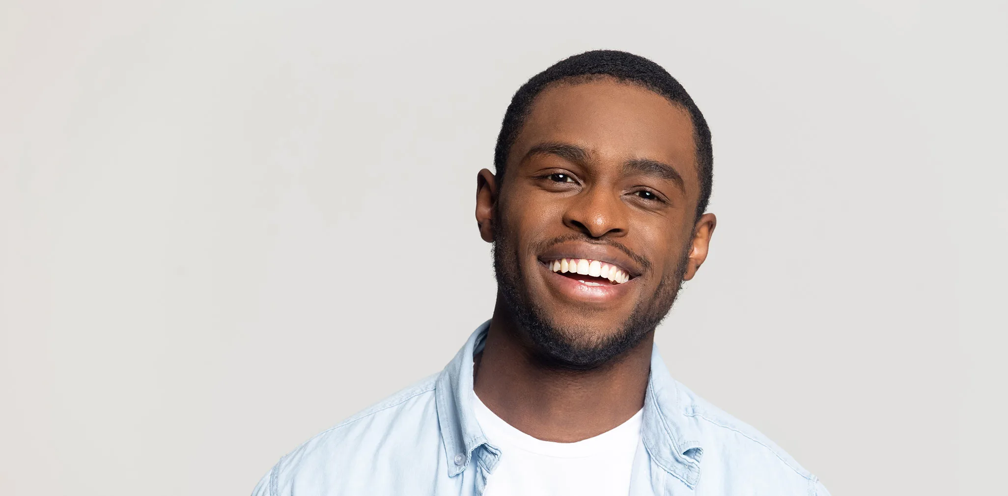Head shot portrait happy African American man with wide healthy smile