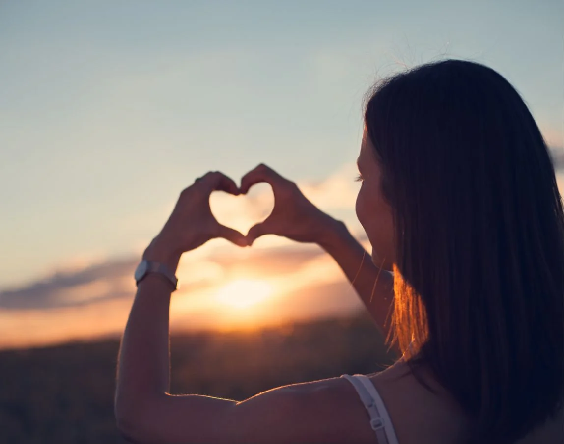 a girl making a heart with fingers