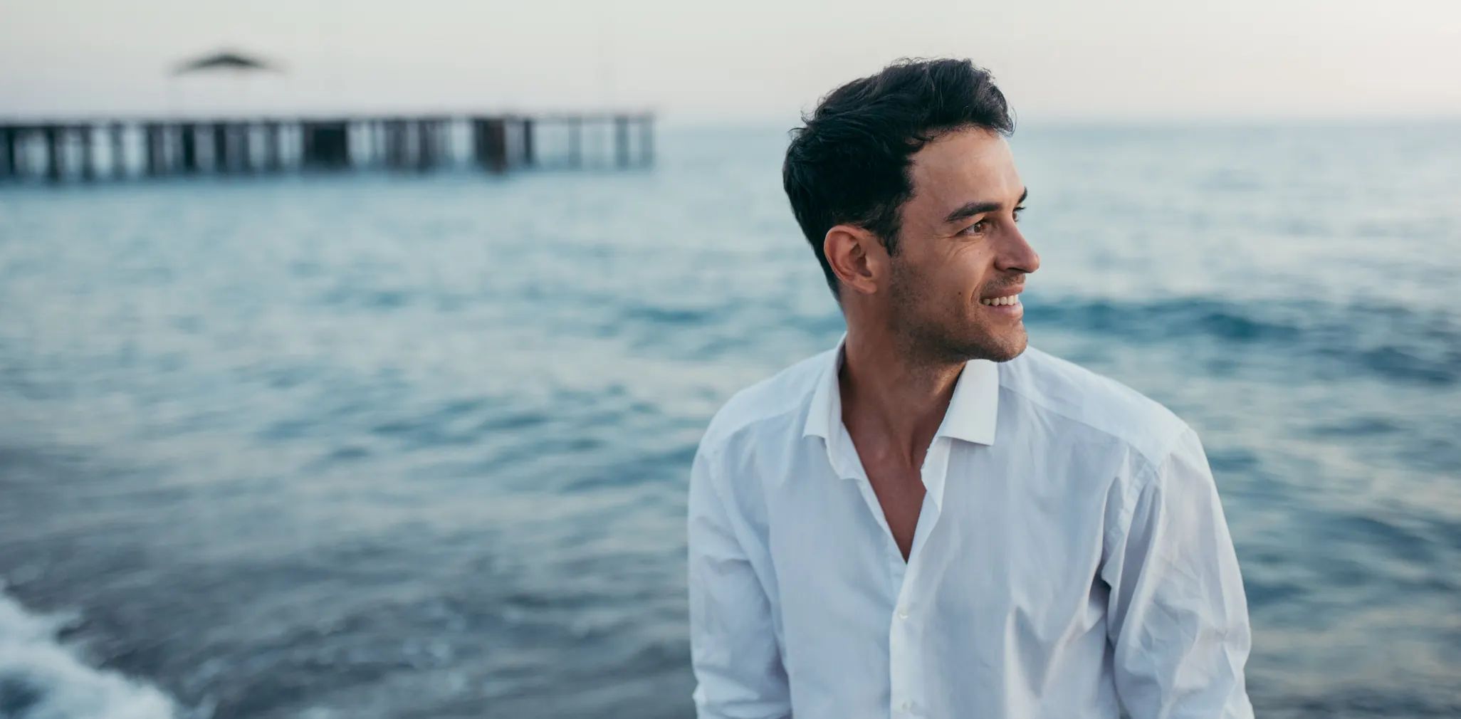 Millennial man watching a sunset and smiling